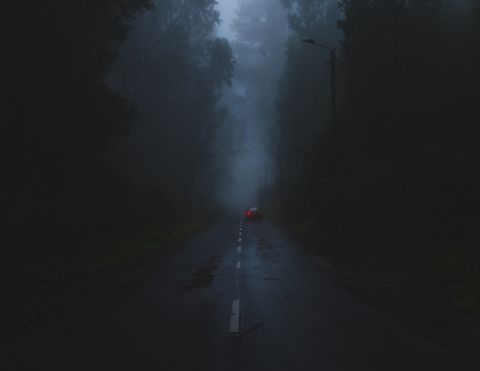 spooky urban legend   road amidst trees against sky during foggy weather