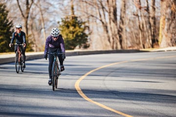 two people riding bikes on a road