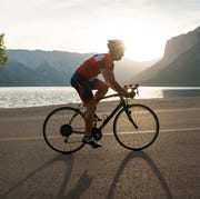 road biker follows mountain road, sunrise