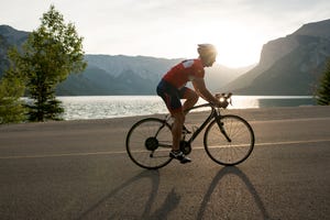 road biker follows mountain road, sunrise