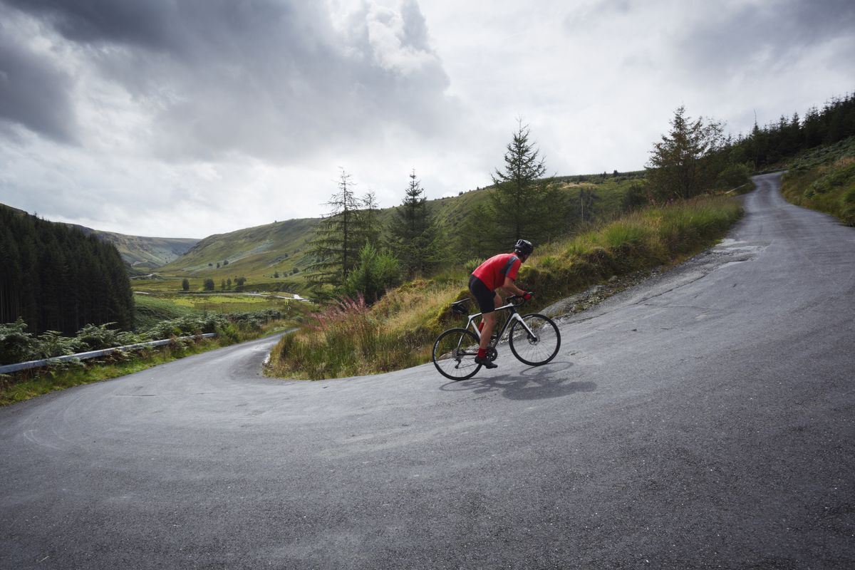 road cyclist climbing hairpin bends up steep road