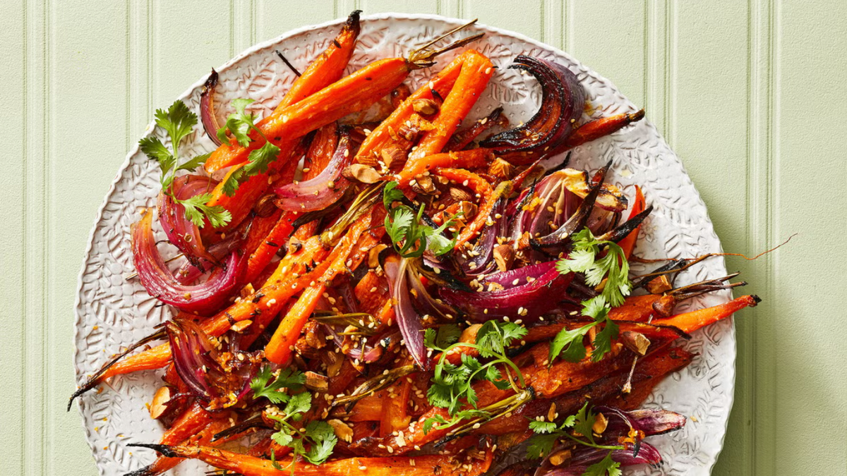 50 Crowd-Pleasing Thanksgiving Vegetable Sides roasted carrots and red onions on white plate