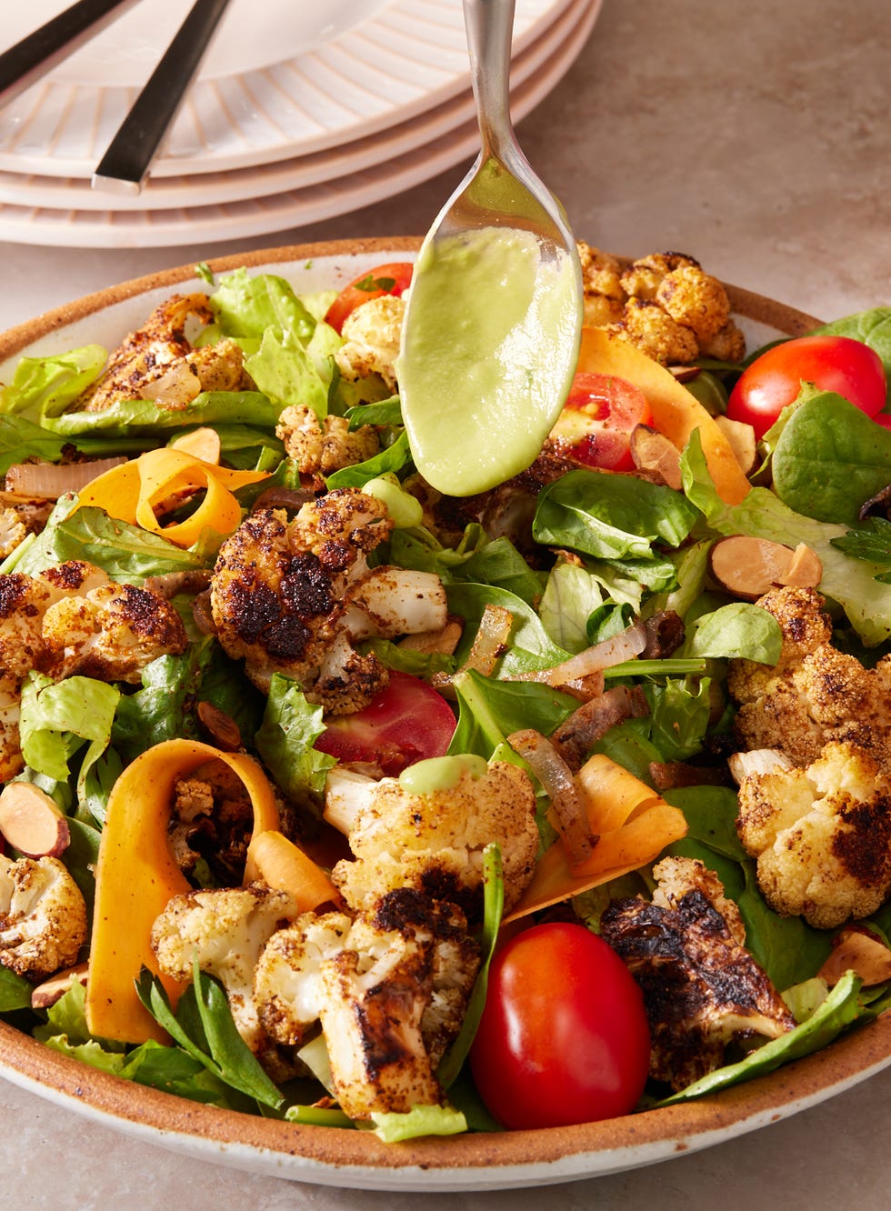 roasted cauliflower and mixed green and romaine salad topped with tomatoes, shaved carrots, and an avocado dressing