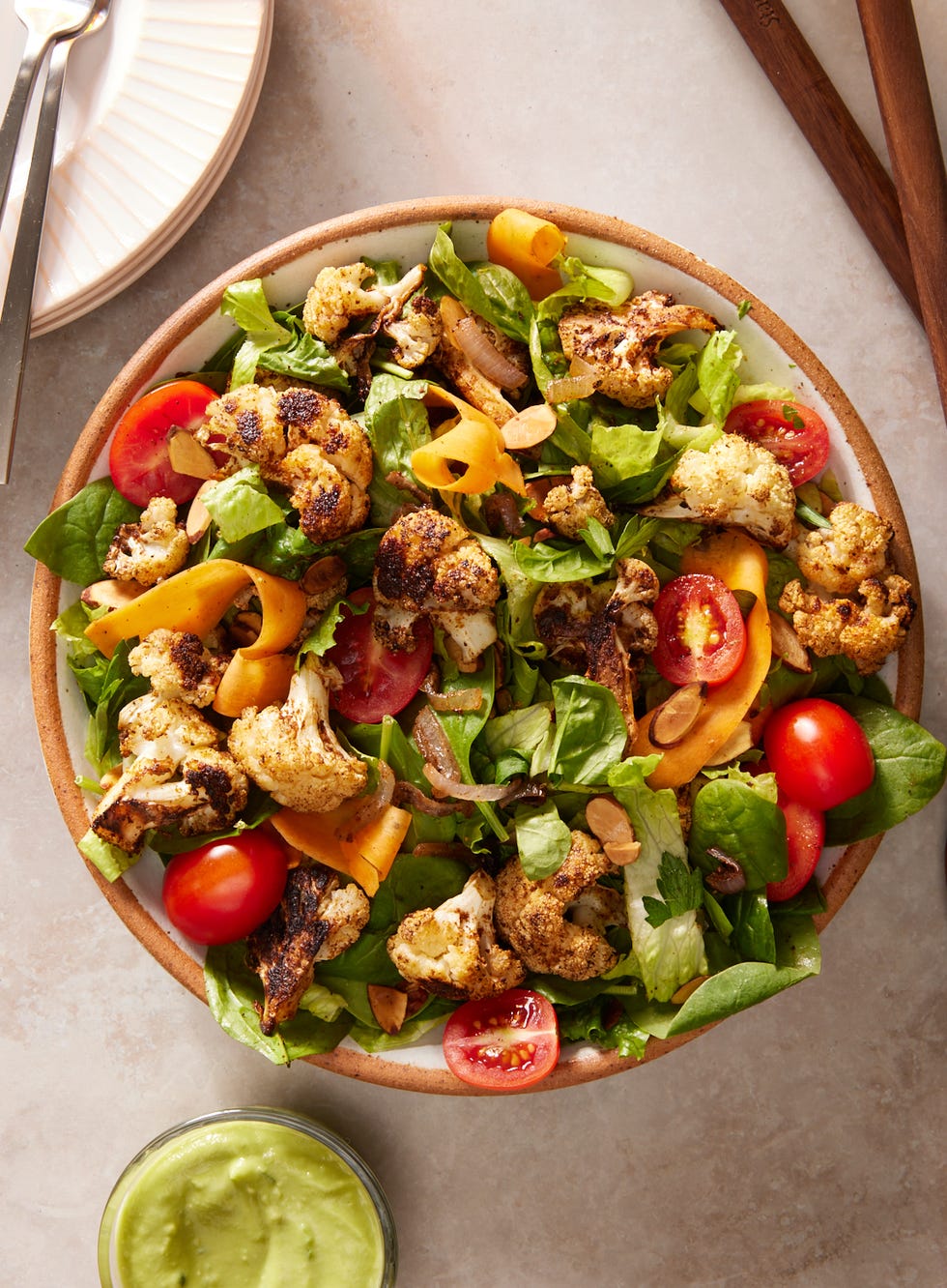 roasted cauliflower and mixed green and romaine salad topped with tomatoes, shaved carrots, and an avocado dressing