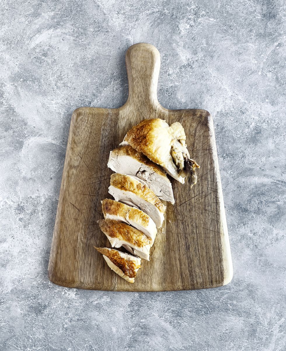 roasted chicken breast on wooden cutting board on gray background