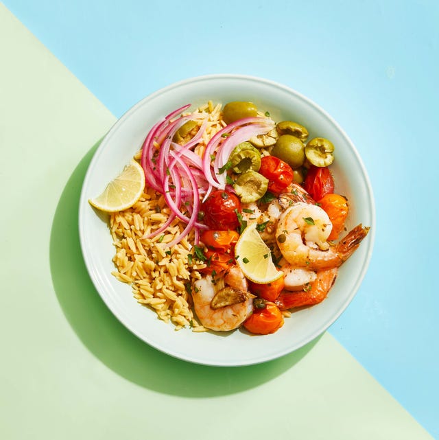 roasted mediterranean shrimp bowl with red onion, rice, tomatoes, olives and lemon