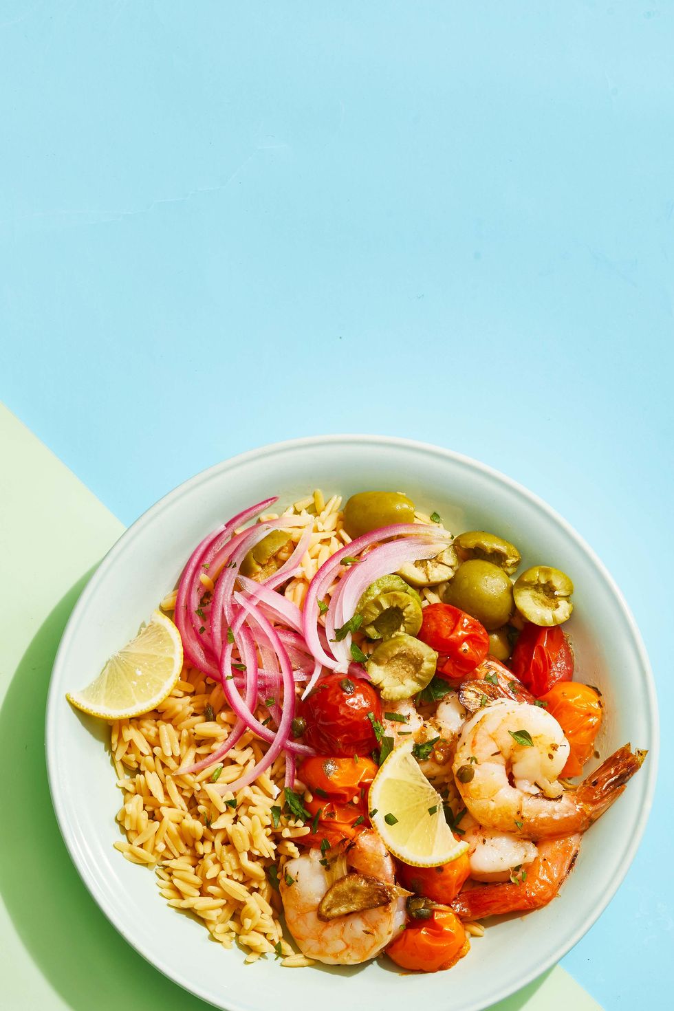 roasted shrimp bowl with red onions, olives, and tomatoes