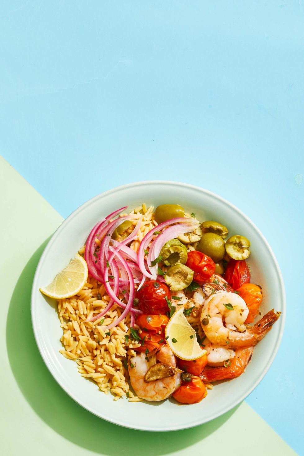 mediterranean shrimp bowl on a blue and green background