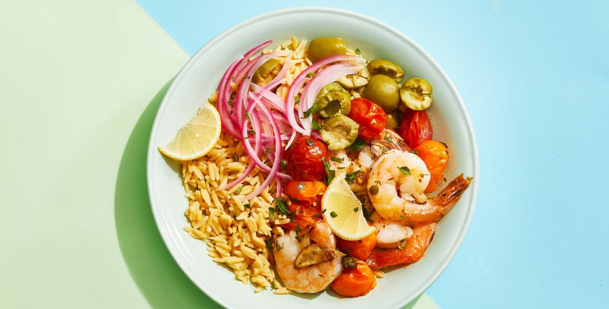 roasted mediterranean shrimp bowl with red onion, rice, tomatoes, olives and lemon