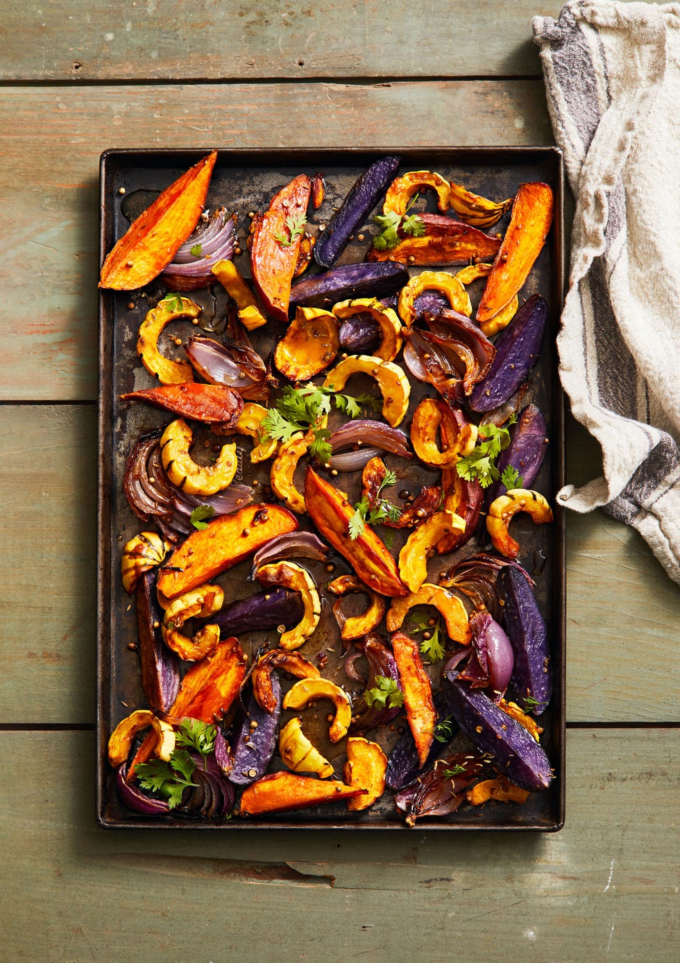 purple and orange roasted root vegetables on a sheet pan