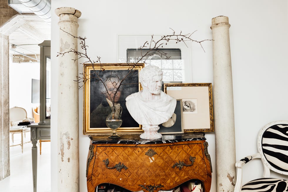 decorative arrangement featuring a bust artworks and a vintage cabinet