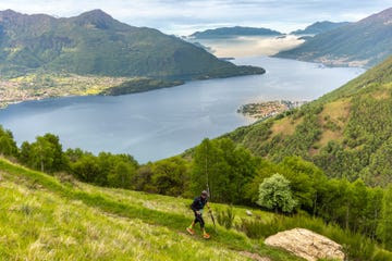 a person hiking on a trail near a lake