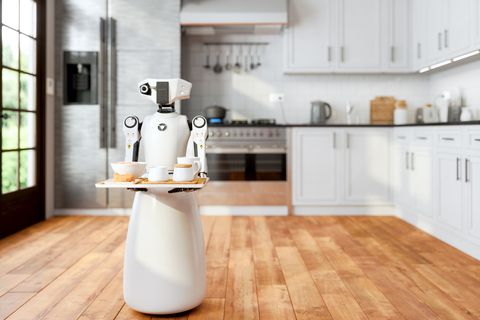 robot maid holding a tray and serving food and drink in modern domestic kitchen with blurred background