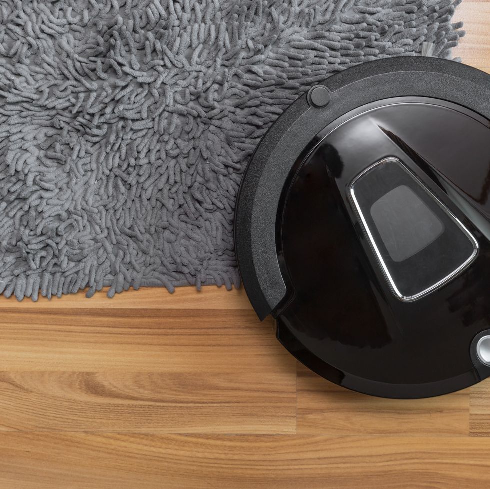 robot vacuum cleaner on laminate wood floor with carpet cleaning