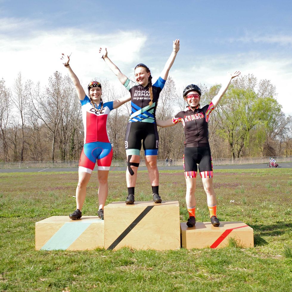 robyn hightman in the center of the podium day 3 of the 6 days of kissena at the kissena velodrome in queens, ny on the left in 2nd place is zsófie sztana, and on the right in 3rd place is dana haberern