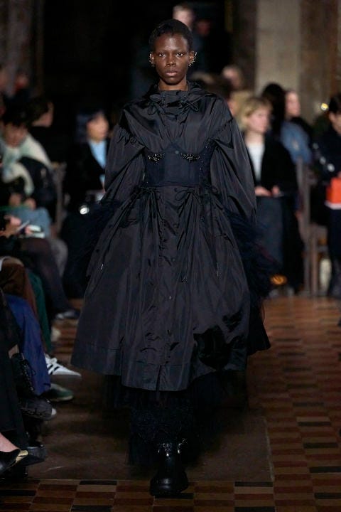 a model wearing a black coat