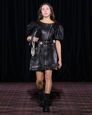 Runway fashion featuring a model in a black leather dress