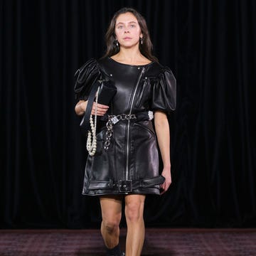 Runway fashion featuring a model in a black leather dress Runway fashion featuring a model in a black leather dress