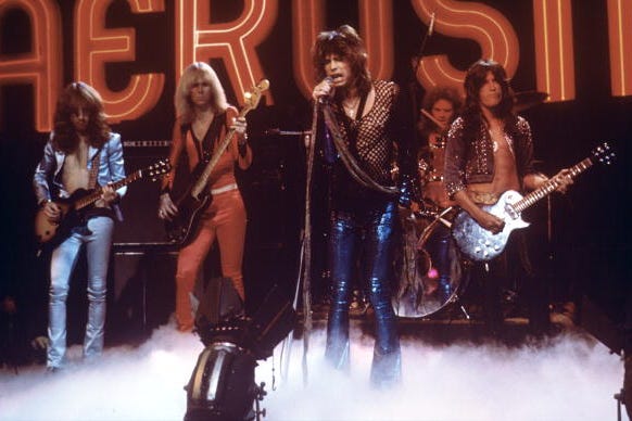 brad whitford, tom hamilton, steven tyler, joey kramer, and joe perry perform on stage