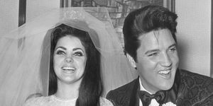 priscilla presley and elvis wearing their wedding attire while smiling and holding hands