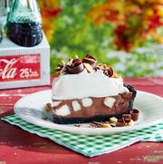 a slice of rocky road pie on a white plate on a red outdoor picnic table