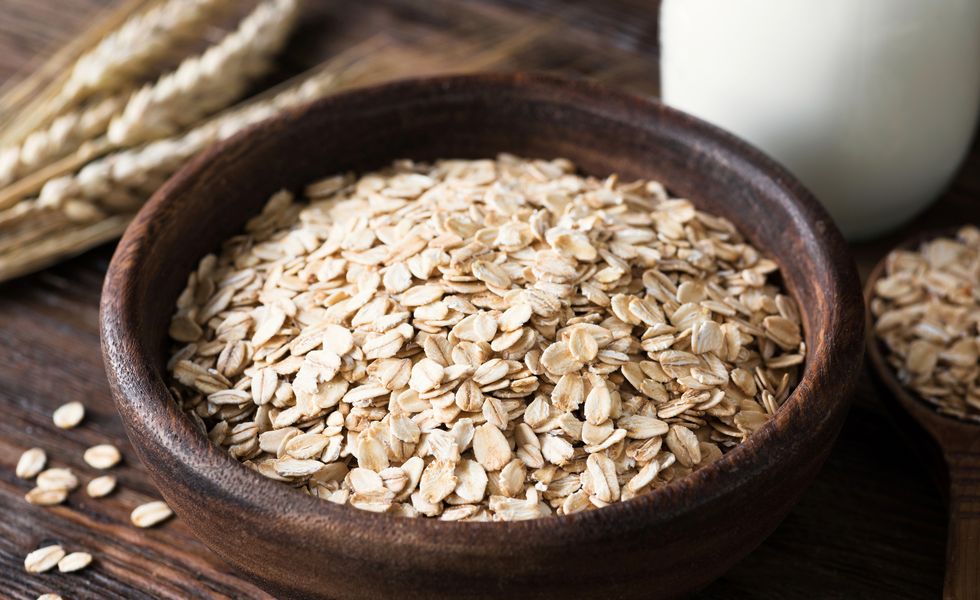rolled oats in wooden bowl on old wooden table