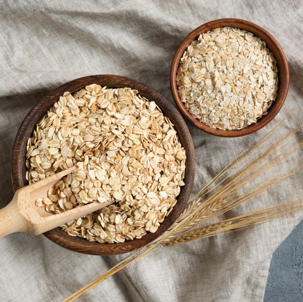 rolled oats, oat flakes in wooden bowl