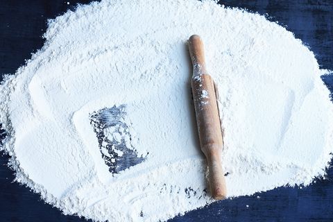 rolling pin and flour on a dark background free space for text top view