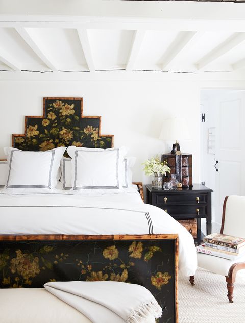 white bedroom with antique black and bamboo bed