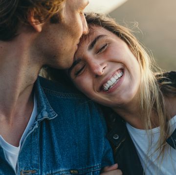 romantic boyfriend kissing on happy girlfriend's forehead