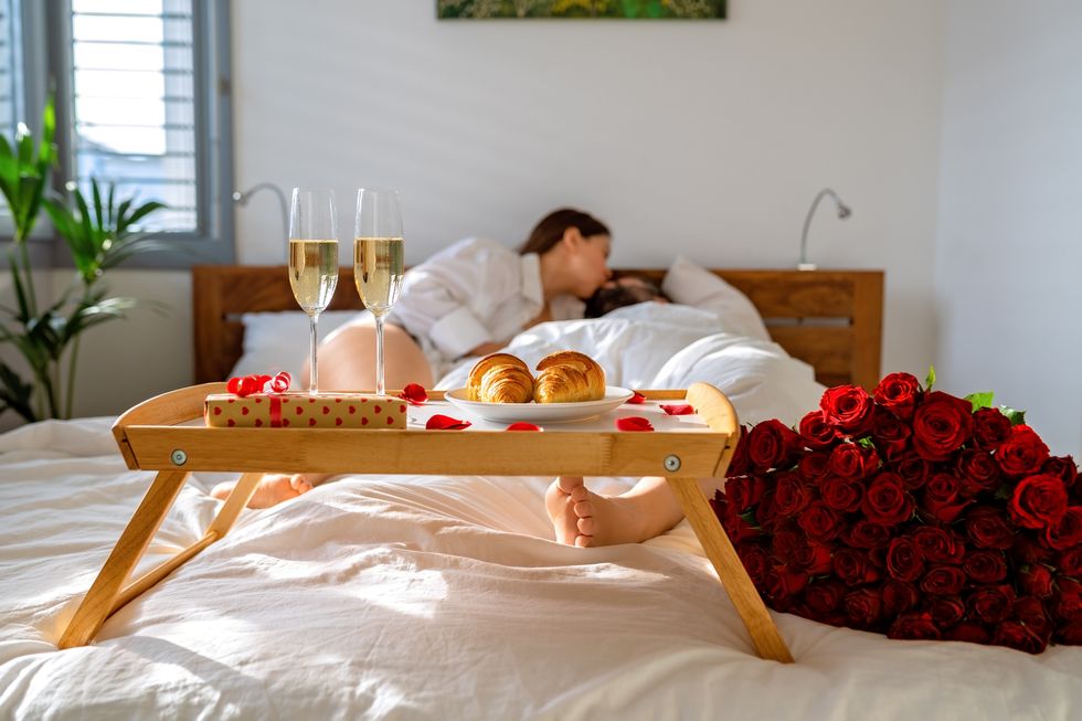 romantic breakfast in bed on valentine day couple kissing and having fun in bed celebrating holiday