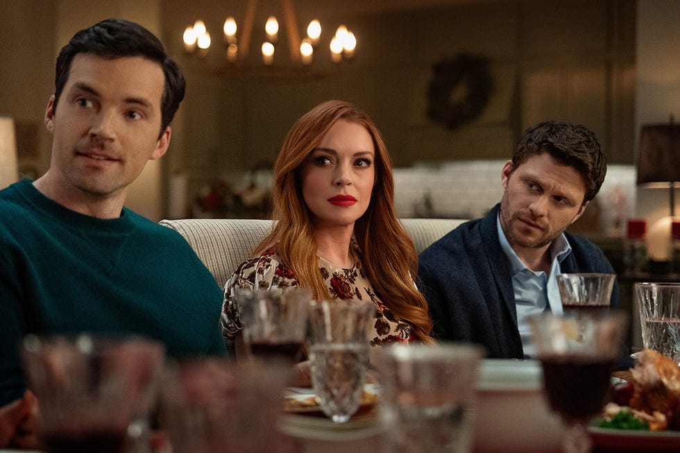 ian harding as logan, lindsay lohan as avery and jon rudnitsky as cameron sit awkwardly around a dinner table in a scene from our little secret