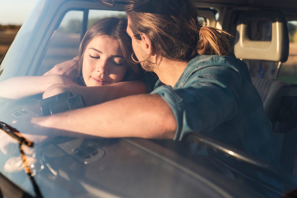 romantic couple sitting in their camper with arms around