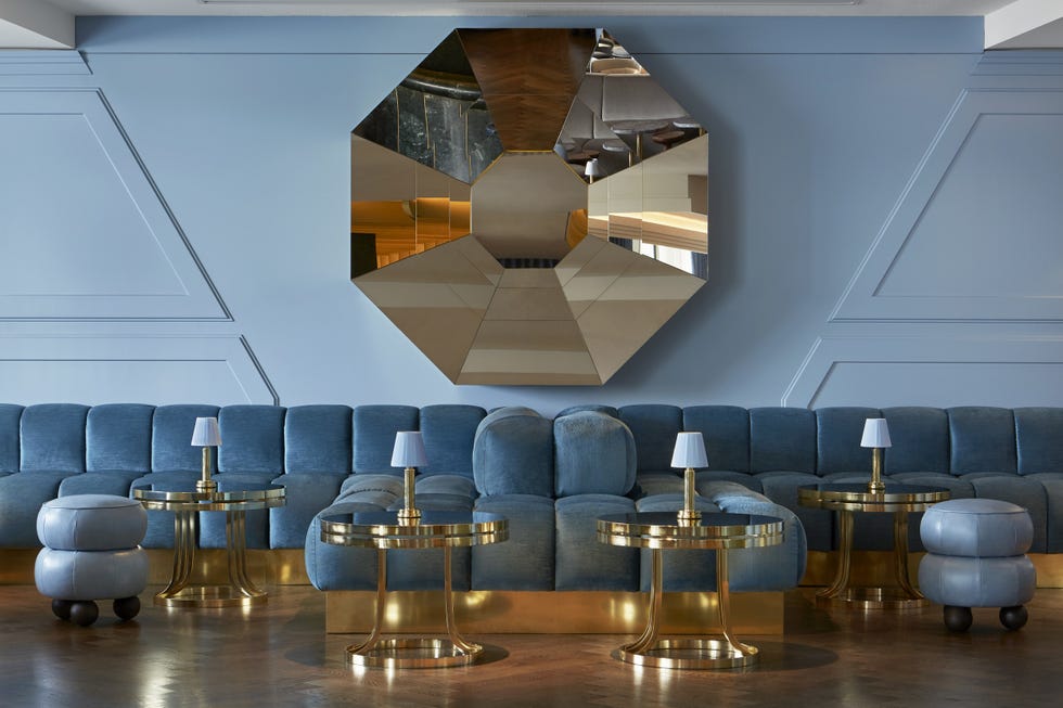 a bar lounge with blue chairs and tables at sea containers