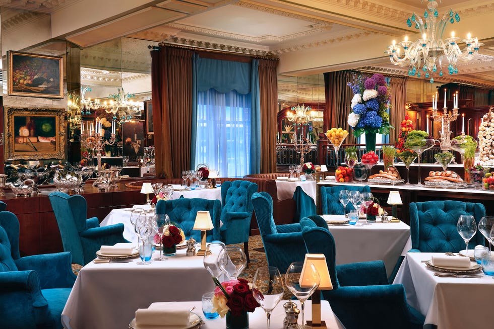a room with tables and blue chairs at rubens at the palace