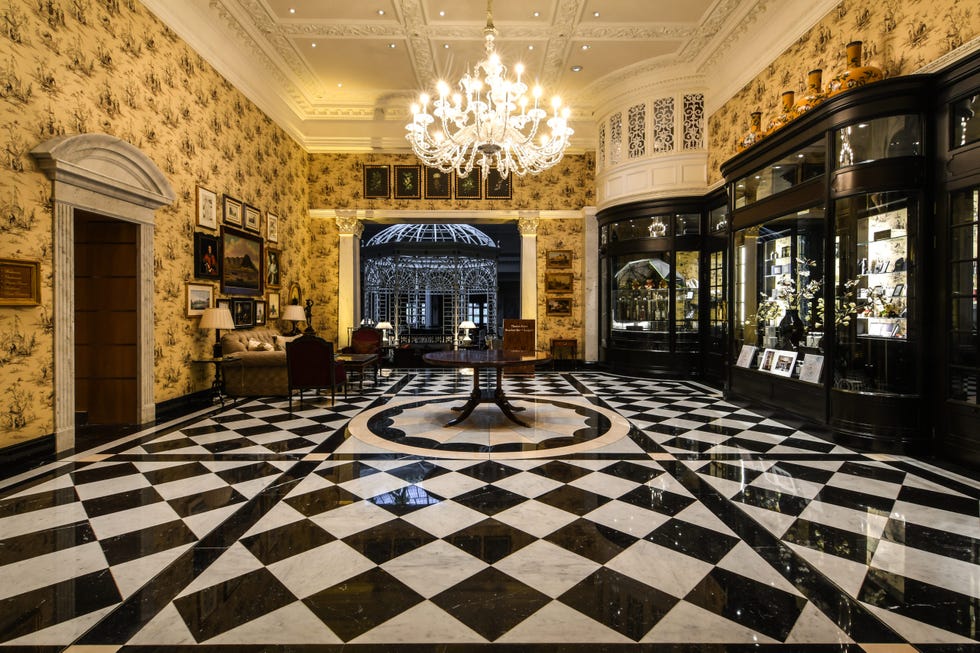 a lobby room with a chandelier and checkered floor