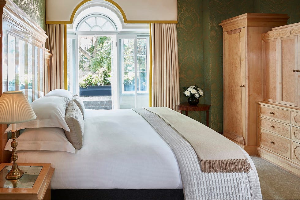 a bed in a room with french windows at the goring