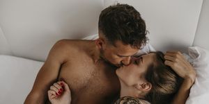 romantic young couple kissing in bed