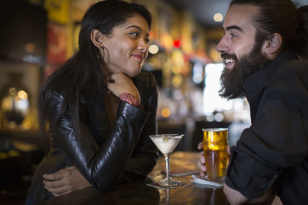 Romantic young couple with cocktail and beer in public house