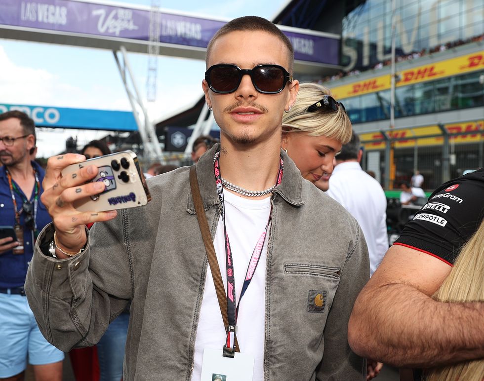 romeo beckham wearing sunglasses and holding out his cell phone to take pictures and photos