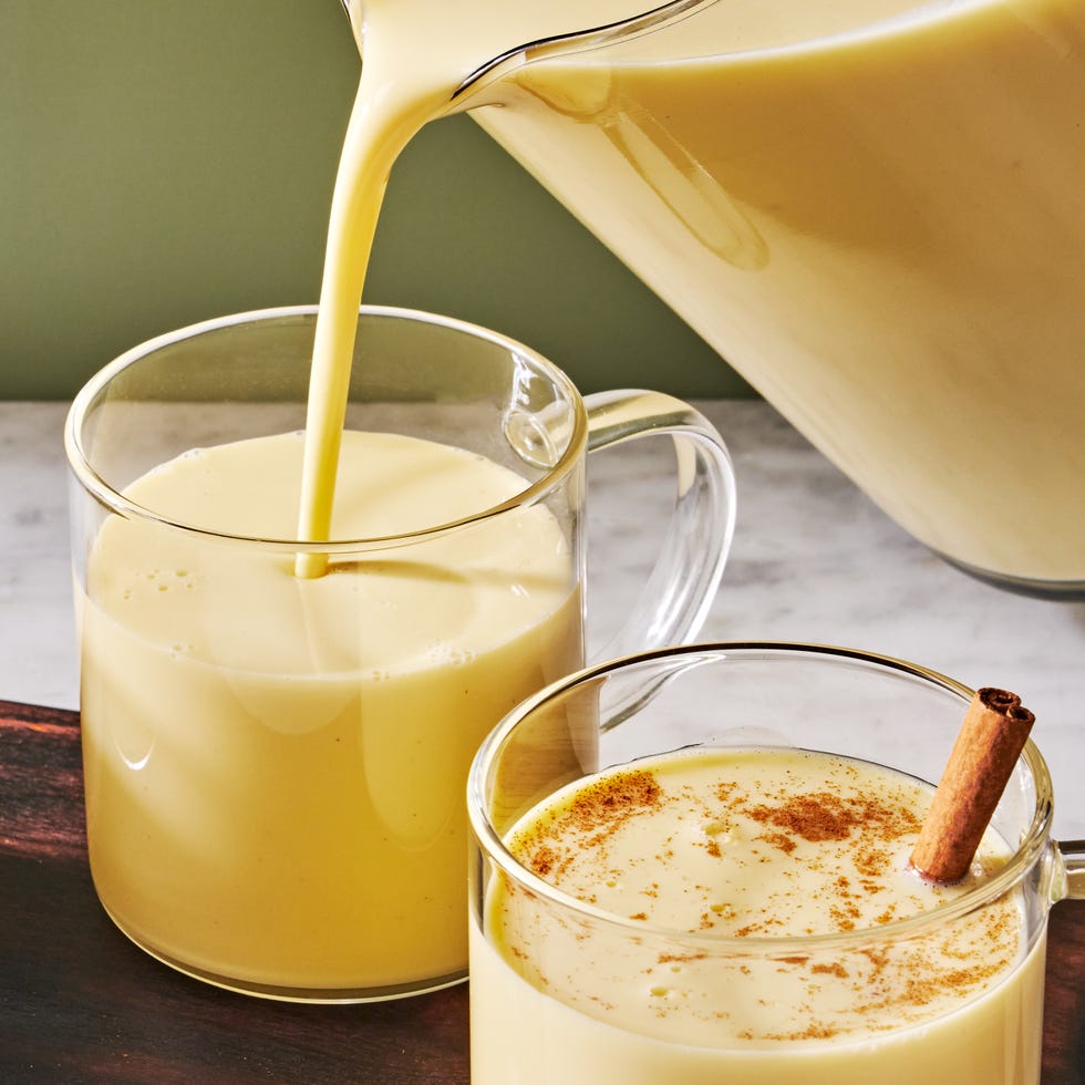 creamy rompope in clear mugs with cinnamon sticks