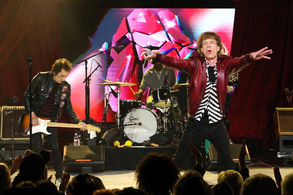 mick jagger singing with the rolling stones on a stage