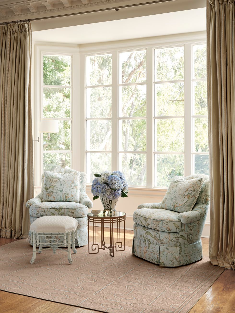 a room with a table chairs and a window with curtains