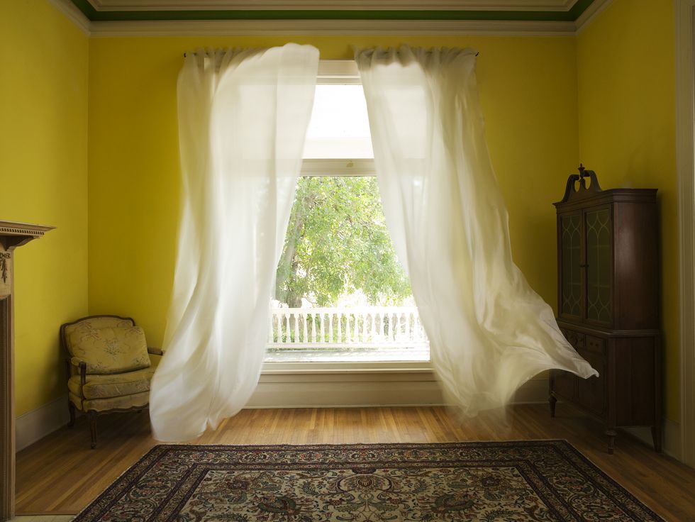 room with curtains billowing at open window
