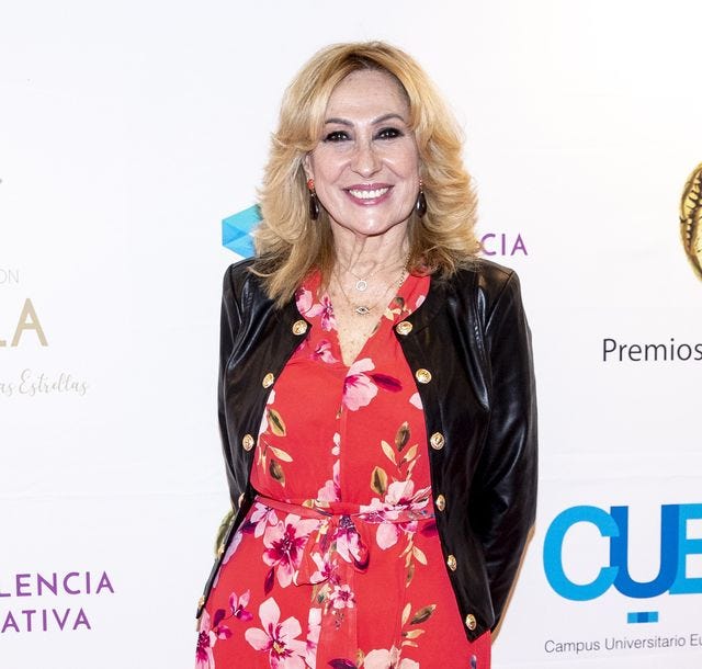 rosa benito posando en un photocall con un vestido de flores