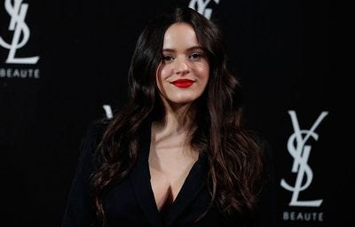 la cantante rosalia posando en photocall vestida de negro y sonriendo