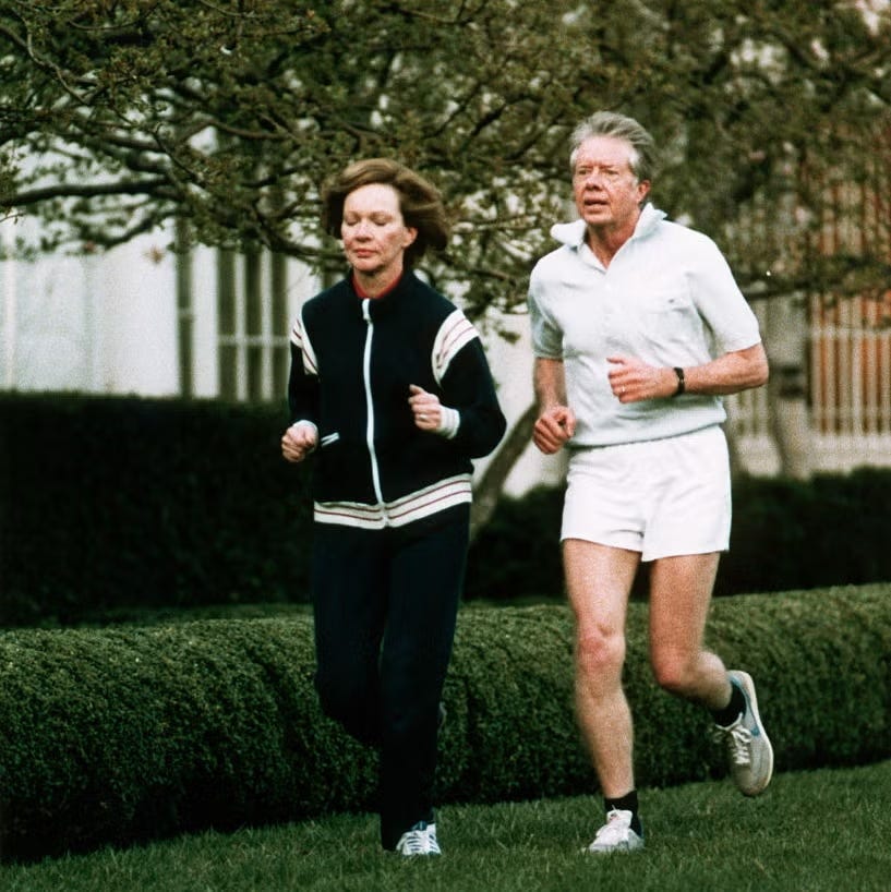 two individuals jogging together in a park setting