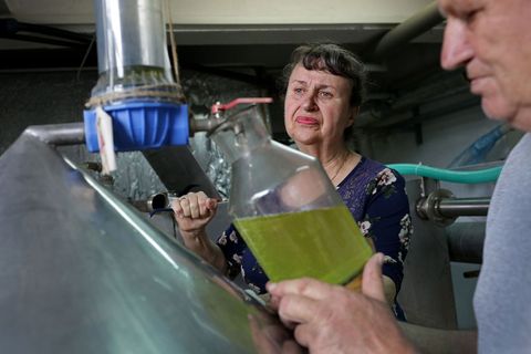 Tijdens het destillatieproces controleren Elena Todorova en haar man Marin directeur van de destilleerderij Lema de rozenolie in de ketels