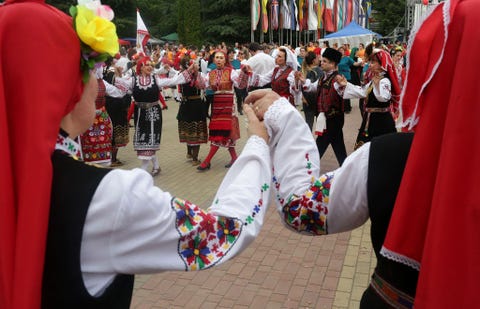 Mannen en vrouwen houden elkaar bij de hand tijdens een traditionele volksdans met subtiele ritmes en gecompliceerd voetenwerk