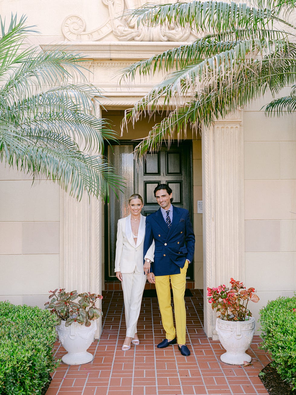 couple standing at an entrance with potted plants